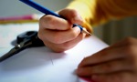 Young person with a pencil, doing some crafting