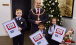 Max McGuinness, Eliezer Renato, Jayden Nicol holding their Christmas card designs with Provost McAllister 